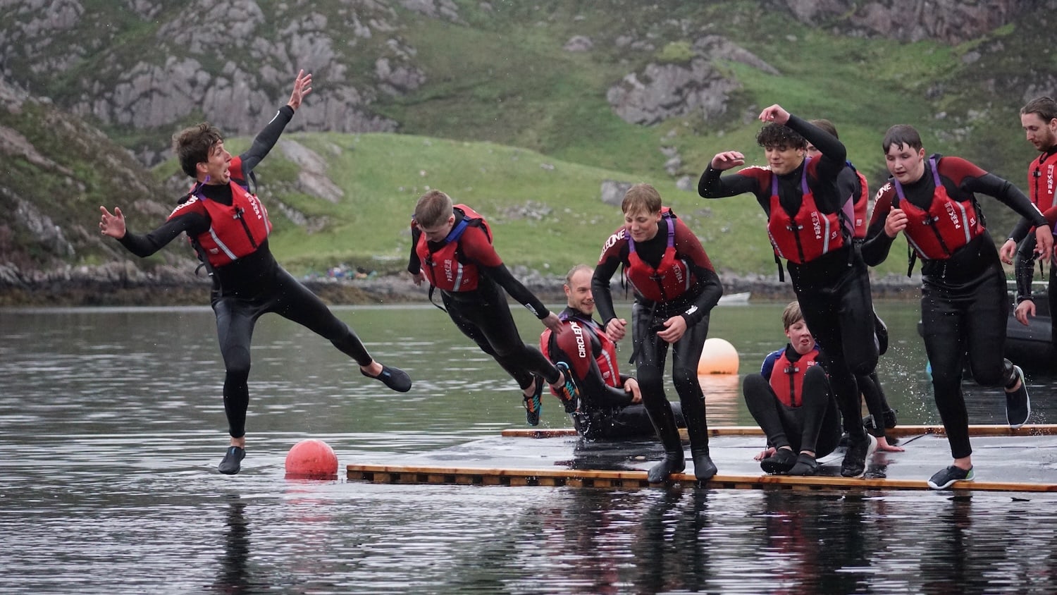 Children jumping from a raft into the sea