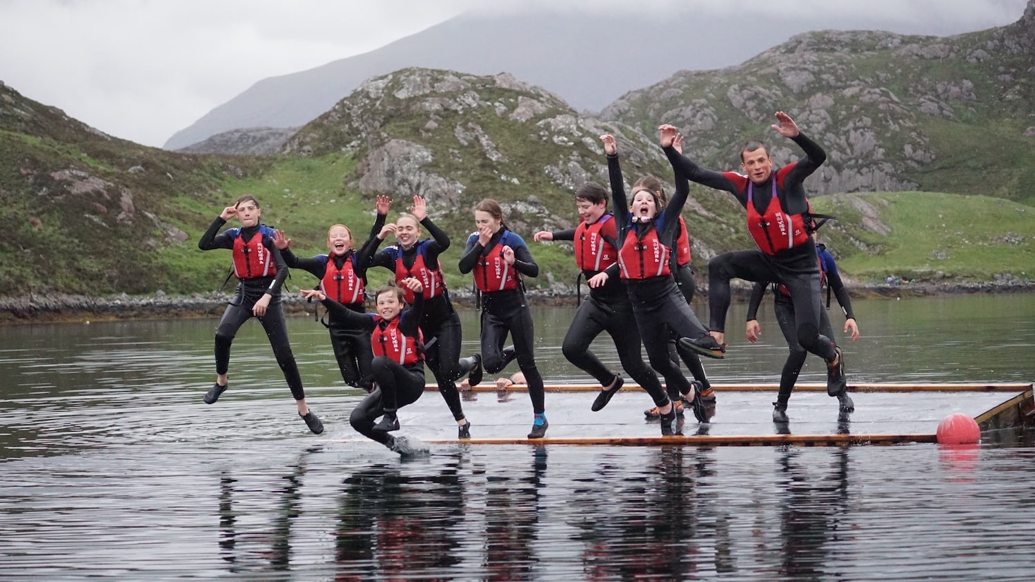 Children jumping into water from a raft